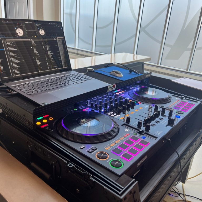 DJ equipment and laptop set up with colorful controls, ready for a performance.