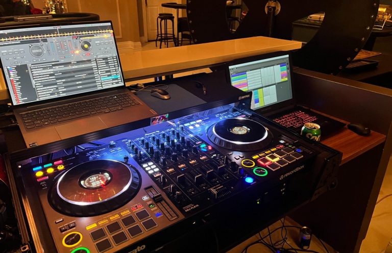 Basic DJ Package DJ setup featuring turntables, mixer, and two screens in a dimly lit environment.