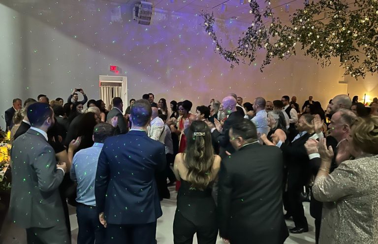 Wedding Dance Party A lively crowd dancing at a celebration in a softly lit venue.